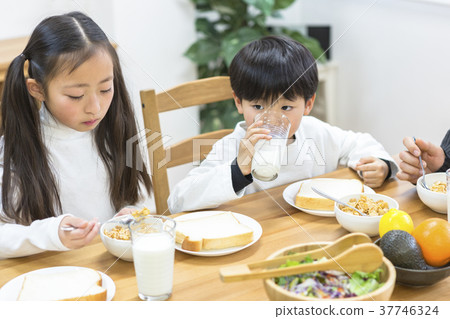 Family surrounding a breakfast table 37746324