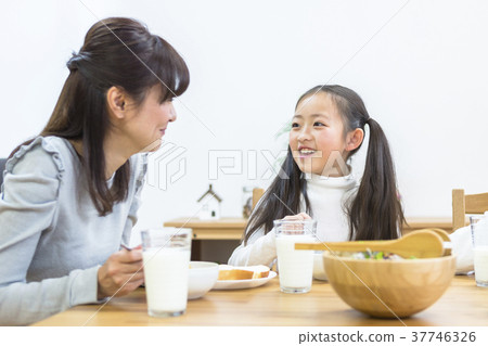 Family surrounding a breakfast table 37746326