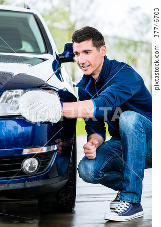 Proud car owner cleaning the headlamps Proud car owner cleaning the headlamps 37746703