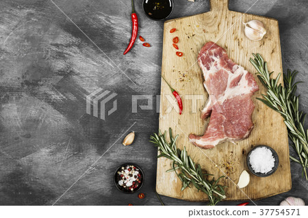 Raw meat with various spices on a wooden board 37754571