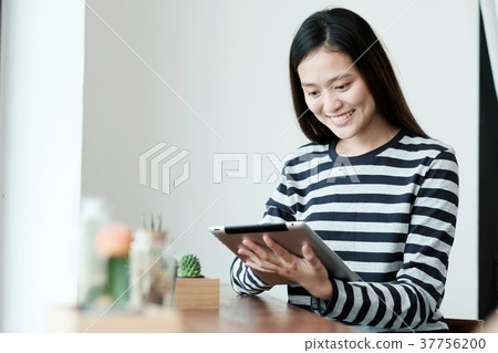 Young asian woman using tablet in cafe background 37756200