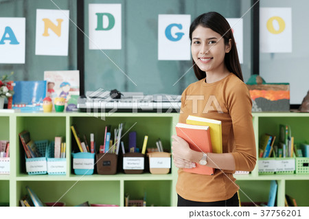 Young asian woman holding books at library Young asian woman holding books at library 37756201
