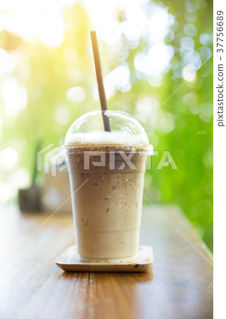 ice coffee on wood table with green nature garden 37756689