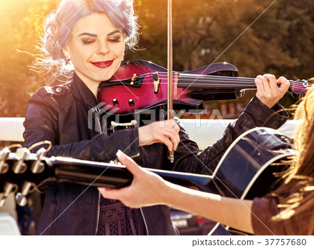Music on violin by woman perform in park outdoor. 37757680