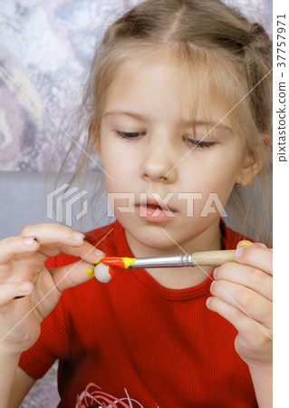 Girl paints a self-made toy  37757971