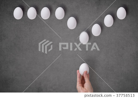 Egg in a female hand on a gray background.  37758513