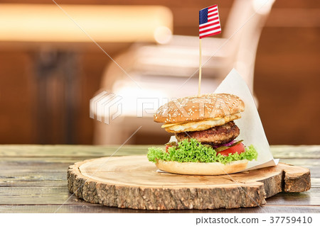 Big hamburger with sticking out american flag. 37759410