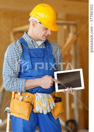 Worker pointing at tablet Worker pointing at tablet 37760302