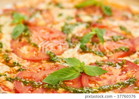 Close up juicy tomatoes and basil on pizza. 37760376