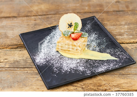 Sweet dish, napoleon cake with fruit slices. Sweet dish, napoleon cake with fruit slices. 37760385