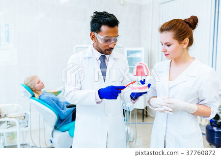 Two Dentist showing jaw model in clinic Two Dentist showing jaw model in clinic 37760872
