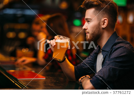 Man drinks beer at the bar counter in a sport pub 37761272