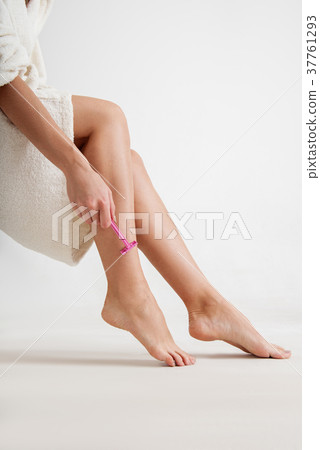 Slim woman using disposable razor 37761293