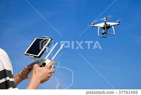 Hands control a drone camera while flying by phone 37761498
