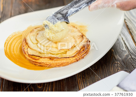 Adding ice cream ball to an apple tart. 37761930