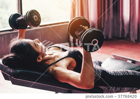 Asian sports woman doing exercises with dumbbell 37768420