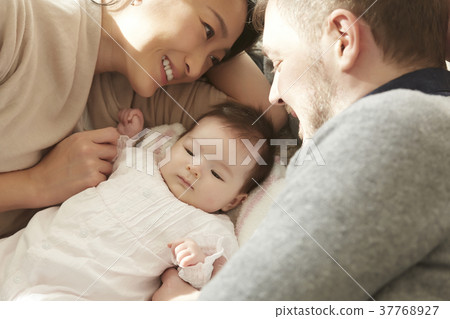 International marriage couple baby lying down International marriage couple baby lying down 37768927