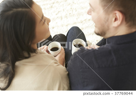 放鬆在客廳咖啡休息的夫婦 放鬆在客廳咖啡休息的夫婦 37769044