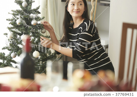 Home Party Woman Decorating a Christmas Tree Home Party Woman Decorating a Christmas Tree 37769431