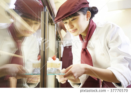 Woman doing part-time job at a cake shop Woman doing part-time job at a cake shop 37770570
