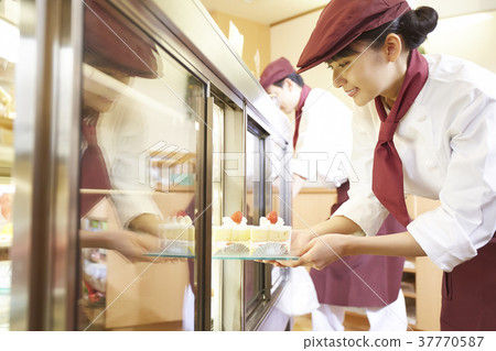 Woman doing part-time job at a cake shop Woman doing part-time job at a cake shop 37770587