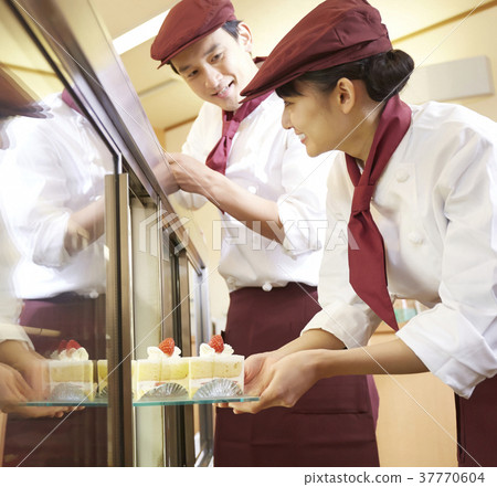 Men and women working in a cake shop 37770604