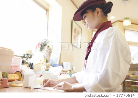 Woman doing part-time job at a cake shop Woman doing part-time job at a cake shop 37770614