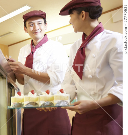 Men and women working in a cake shop Men and women working in a cake shop 37770635