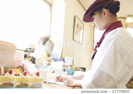 Woman doing part-time job at a cake shop Woman doing part-time job at a cake shop 37770697