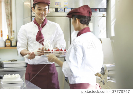 Men and women working in a cake shop 37770747