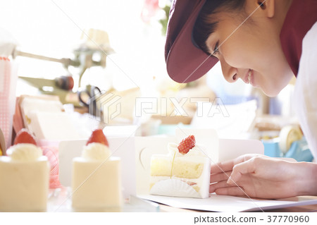 Woman doing part-time job at a cake shop Woman doing part-time job at a cake shop 37770960