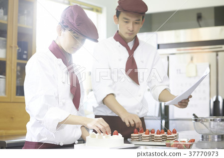 Men and women working in a cake shop 37770973