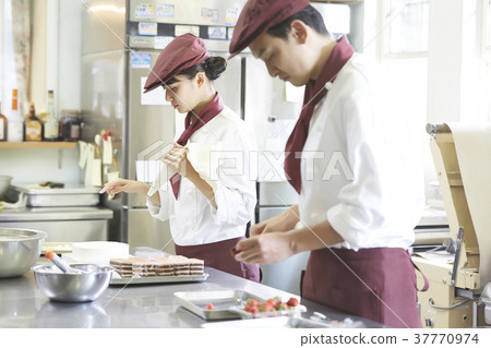 Men and women working in a cake shop 37770974