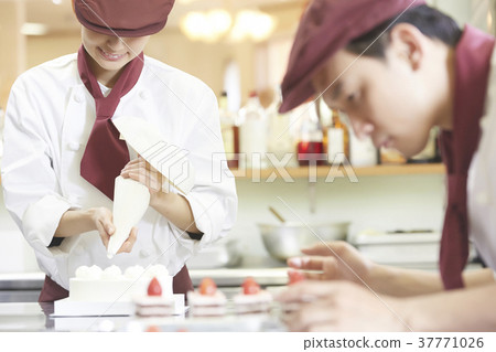 Men and women working in a cake shop 37771026