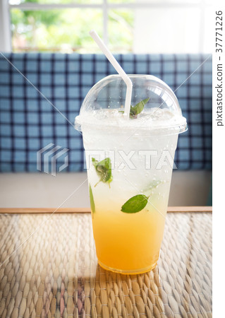 Ice lemon tea with mint and soda. In plastic cup. 37771226