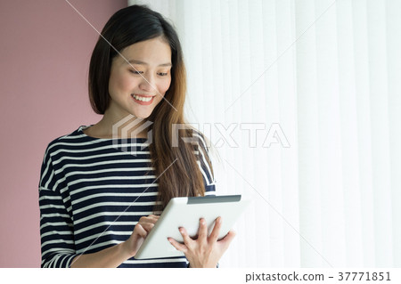 asian business owner using tablet in home office 37771851