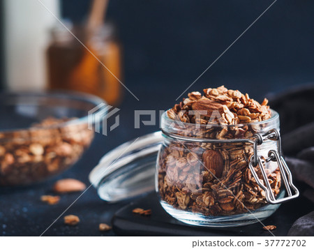 Homemade granola in glass jar on dark table Homemade granola in glass jar on dark table 37772702