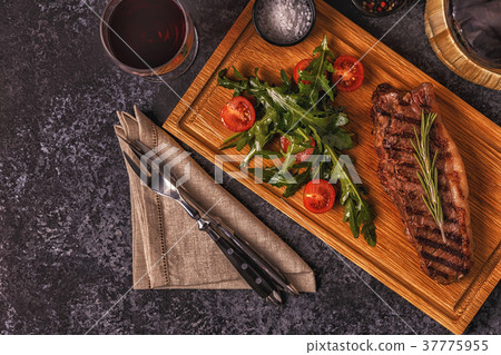 Beef steak on a dark background. Beef steak on a dark background. 37775955