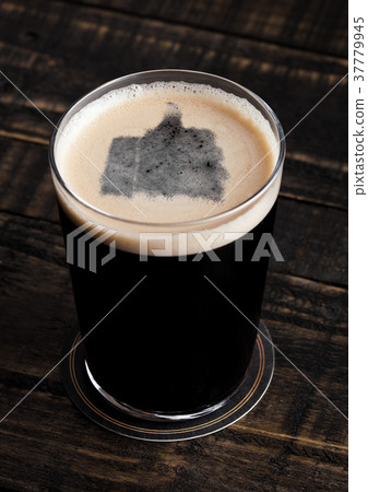 Glass of stout beer top with like symbol shape 37779945