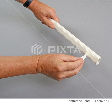 Handyman removing protection from adhesive layer 37782337