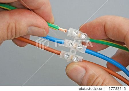 Closeup of hands holding a wire connector 37782343