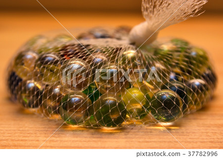 Colorful glass marbles in net 37782996