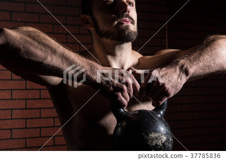 Close-up of a muscular man lifts kettlebell 37785836