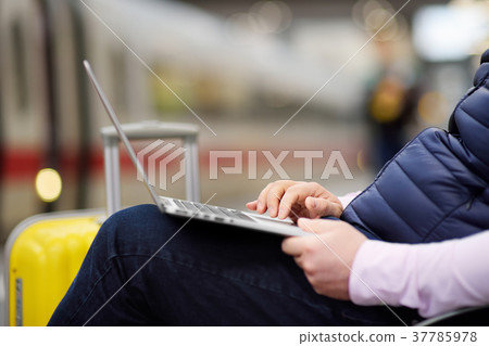 Freelancer working with laptop in a train station Freelancer working with laptop in a train station 37785978