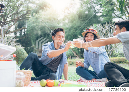 Young teen groups picnic in park together. 37786300