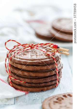 Stack of chocolate cookies tied with a cord. 37789458