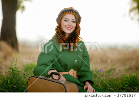 portrait of adult girl in green coat with suitcase portrait of adult girl in green coat with suitcase 37791617