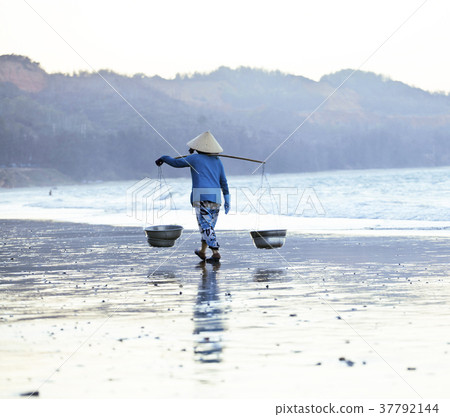 vietnam woman in vietnamese hat walking on seacost 37792144