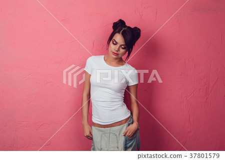 Attractive woman in a white t-shirt stands on a 37801579
