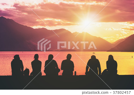 Silhouette Group of Young People Sitting on Beach 37802457